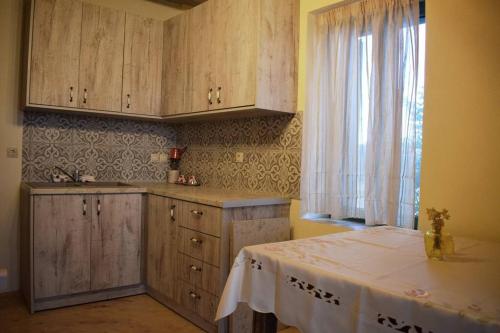 uma cozinha com armários de madeira, uma mesa e uma janela em Studio Drogari em Éxo Apídhion