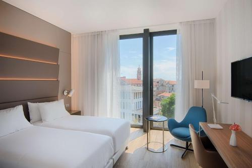 a hotel room with a bed and a desk and a window at Avani Rio Novo Venice Hotel - previously NH Venezia Rio Novo in Venice