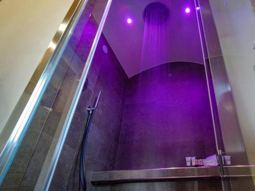 baño con ducha con iluminación púrpura en Relais 5 Sensi WELLNESS & SPA, en Bagnoli Irpino