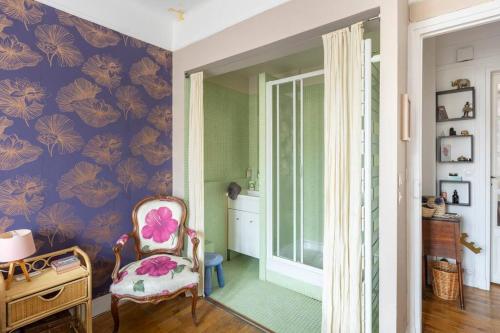 パリにあるAppartement 4 chambres avec balcon dans quartier comme un villageの紫の壁の客室で、椅子と窓が備わります。