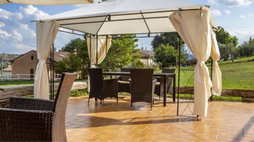 a table and chairs under an umbrella on a patio at Villa Domus - Homelike Villas in Montegiorgio