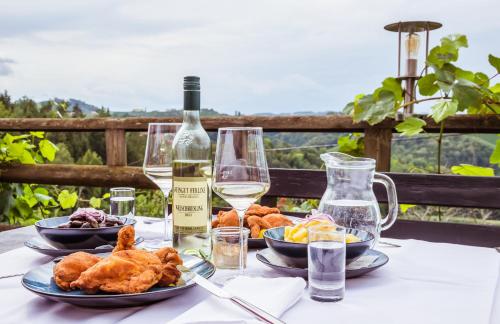 a table with two plates of food and a bottle of wine at eckbergerhof in Gamlitz