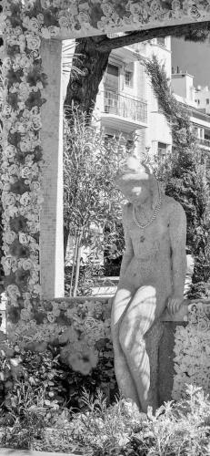 a statue of a man sitting on a wall at Hôtel Eden - La Baigneuse in Juan-les-Pins
