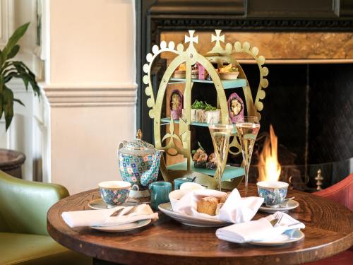 a table with plates of food and a fireplace at Castle Hotel Windsor in Windsor