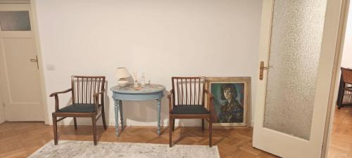 a dining room with two chairs and a table with a painting at Luxury Apartment 3 Rooms in Bucharest