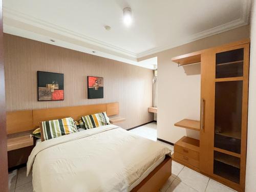 een slaapkamer met een bed en een tv. bij Galeri Ciumbuleuit Apartment 1 2BR 1BA - code 12B in Bandung
