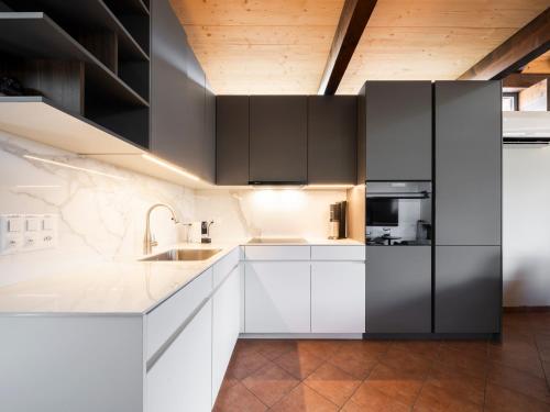 a kitchen with black and white cabinets and a sink at Il Rustico Claro in Bellinzona
