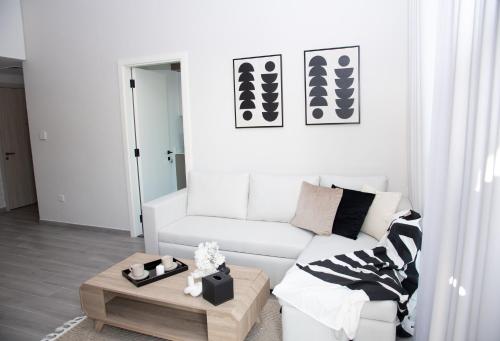 ein Wohnzimmer mit einem weißen Sofa und einem Couchtisch in der Unterkunft Tamm - Noor 4 Tower in Dubai