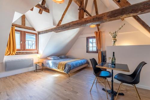 1 dormitorio con 1 cama, mesa y sillas en Centre-ville le nid d'amour jacuzzi appartement, en Rouen