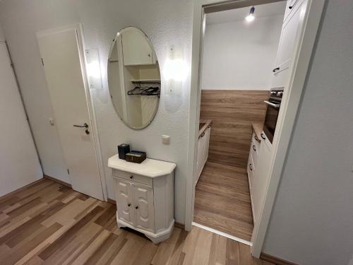 une salle de bain avec un lavabo et un miroir au mur dans l'établissement Prinzenhof, Whg 2, à Grömitz