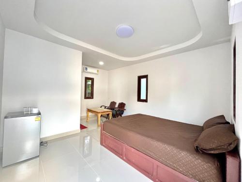 a bedroom with a bed and a table in a room at Kunaeng ครัวกันเอง รีสอร์ท in Ban Nong Pla Lai