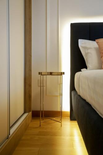 a side table next to a bed in a room at Supernova Royal Residence in Novi Sad