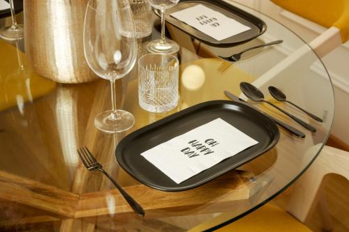 a table with a plate on a glass table at Supernova Royal Residence in Novi Sad