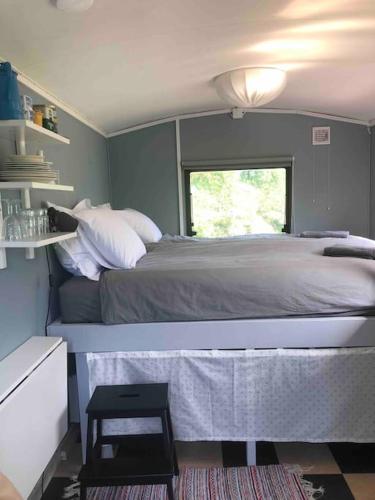a bedroom with a large bed with a window at Agundaborg Lake hut with a view in Agunnaryd