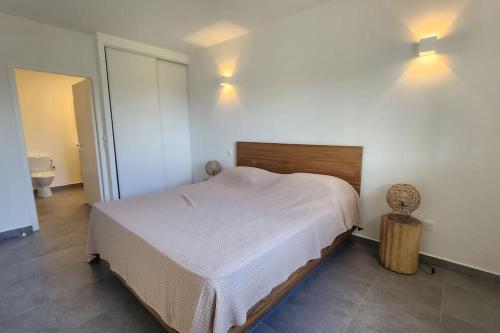 1 dormitorio con 1 cama y 2 luces en la pared en Friar's beach - Luxurious unit by the beach, en Saint Martin