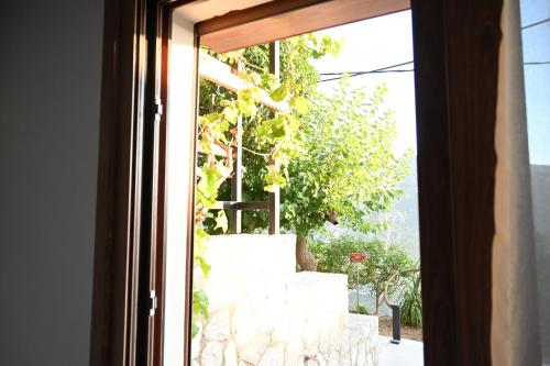 an open window with a view of a tree at Komody in Delfoi