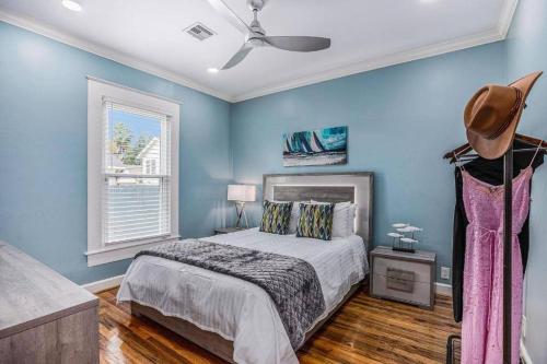 a bedroom with blue walls and a bed with a hat at Luxury Designer Villa by the Beach Bright Beautiful Brand New in Galveston