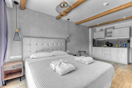 a bedroom with a white bed with two towels on it at Komody in Delfoi