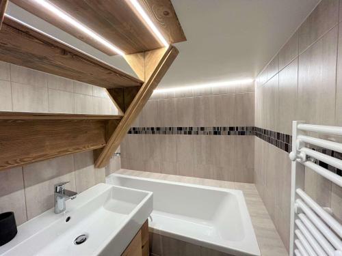 une salle de bain avec une baignoire blanche et un lavabo dans l'établissement Appartement familial 4 pièces, ski-in/ski-out, 8 pers, Méribel - FR-1-180-596, à Les Allues