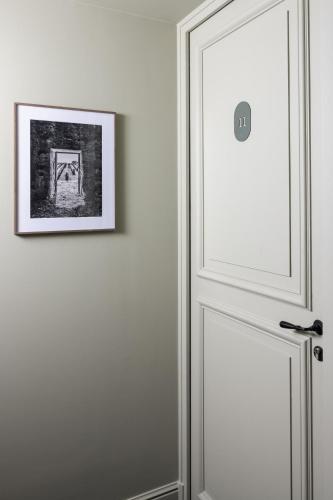 a white door with a picture on the wall at Hotel Porte Brunet in Saint-Émilion