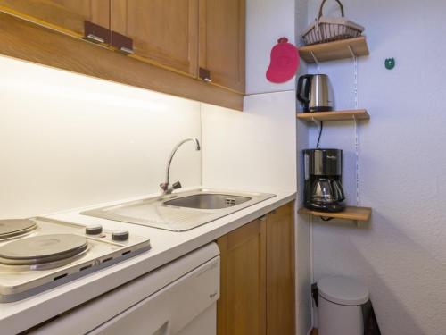 une petite cuisine avec un évier et une cuisinière dans l'établissement Studio chaleureux au centre, proche des pistes avec balcon - FR-1-181-2510, à La Plagne Tarentaise