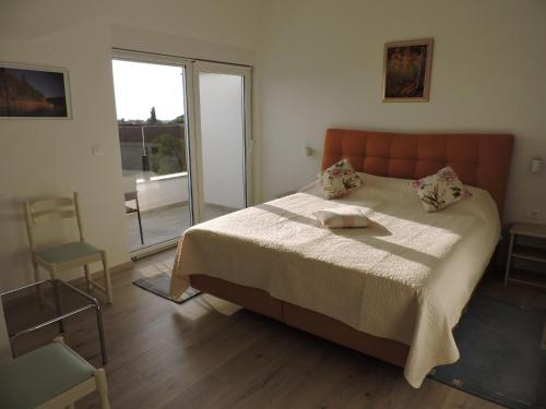 a bedroom with a bed and a chair and a window at Pansion Berat in Vodnjan