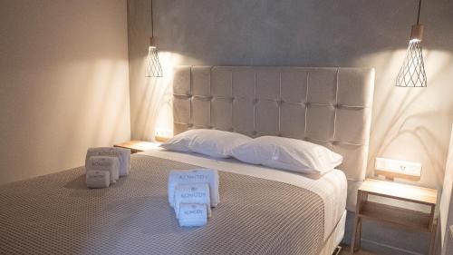 a bedroom with a white bed with two towels on it at Komody in Delfoi