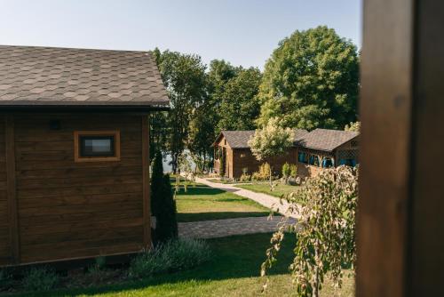 uma cabana de madeira com um caminho que leva a duas casas em СИНІ ВОДИ база відпочинку 