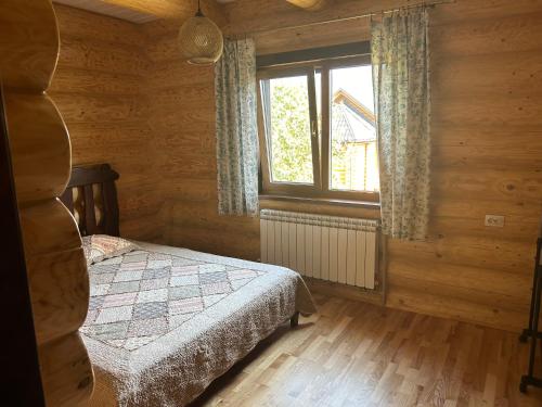 Un dormitorio pequeño con una cama y una ventana. en Karpaty, en Yaremche