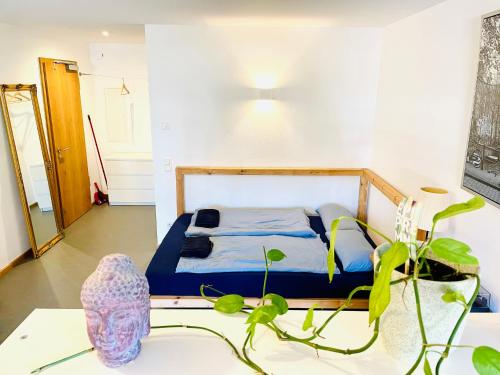 ein Schlafzimmer mit einem Bett und einem Tisch mit einer Pflanze in der Unterkunft Helle Souterrain Wohnung in Laufnähe zum Wörthsee in Wörthsee