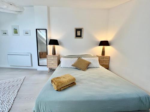 a white bedroom with a large bed with a blanket at Maison de village Arty et terrasse au calme in Lourmarin