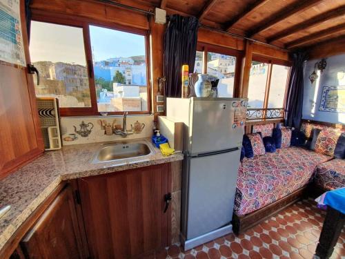 a kitchen with a refrigerator and a sink in a rv at Casa Meftah Blue in Chefchaouene