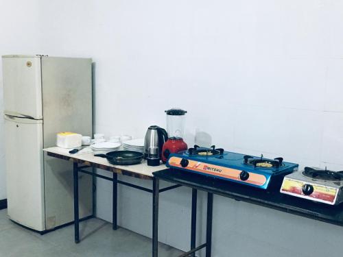 una cocina con estufa y refrigerador en New Stay Inn, en Bentota