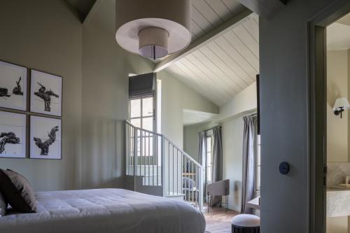 a bedroom with a bed and a stair case at Hotel Porte Brunet in Saint-Émilion