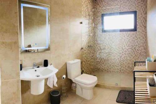 een badkamer met een wit toilet en een wastafel bij Magnifique villa avec piscine au cœur des palmiers in Marrakesh
