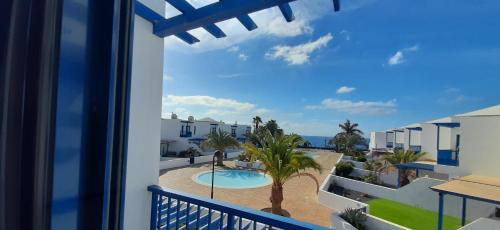 vistas a la piscina desde el balcón de una villa en Las Moreras Playa Blanca en Playa Blanca