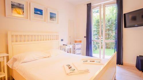 um quarto com uma cama, uma televisão e uma janela em La Terrazza sul Lago - Italian Homing em Polpenazze del Garda