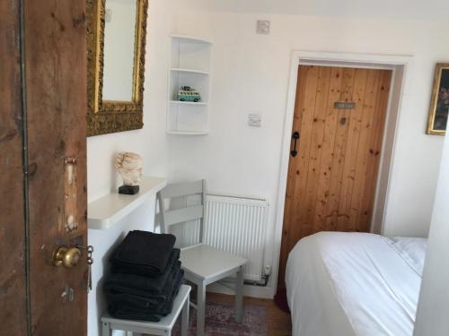 a bedroom with a bed and a desk and a door at Angel Cottage Cozy Nook in Boxgrove