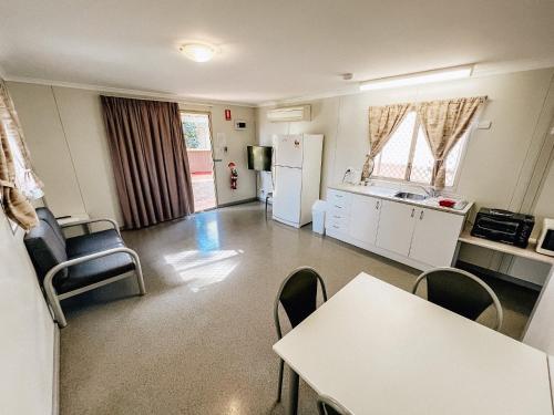 a kitchen with a table and chairs in a room at Karratha Village Workforce Accommodation in Karratha