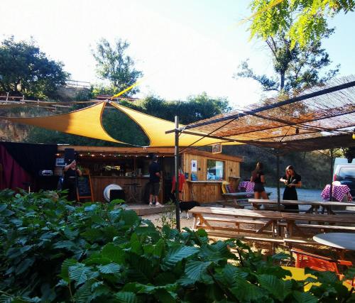 eine Terrasse mit einem gelben und grünen Sonnenschirm in der Unterkunft Ferme de Samson in Saint-Péray