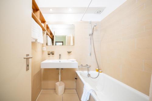 La salle de bains est pourvue d'un lavabo et d'une baignoire. dans l'établissement 2205 Schoen eingerichtete Wohnung mit stilvollem Flair, à Vulpera