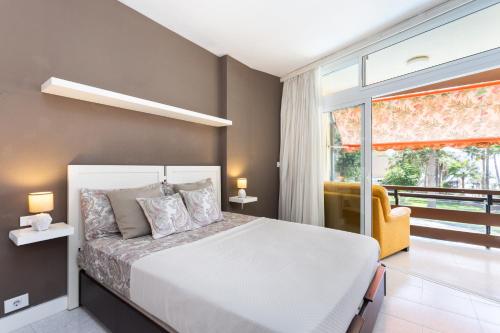 a bedroom with a white bed and a window at Appartamento fronte mare a Playa de Las Vistas in Arona