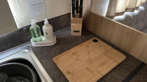 a kitchen counter with a cutting board next to a sink at 27 Rickardos Holiday Lets in Louth
