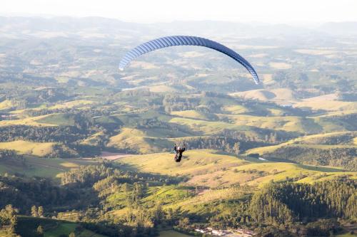 a person flying a parachute in the air at Hotel Dan Inn Poços de Caldas - A melhor localização do Centro by Nacional Inn in Poços de Caldas