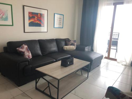 salon z czarną kanapą i stołem w obiekcie Klimentos Flat 59 w Nikozji