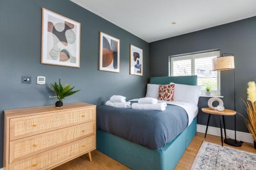 a bedroom with a blue bed and a dresser at Apartment, 2 rooms , up to 5 guests, free pkg -pkg by Tent serviced Apartments in Egham