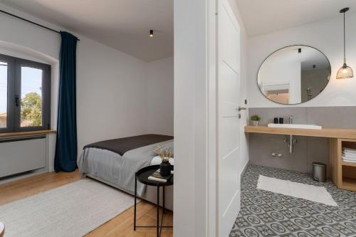 a bedroom with a bed and a sink and a mirror at Modern villa Molindrio with pool in Porec in Poreč