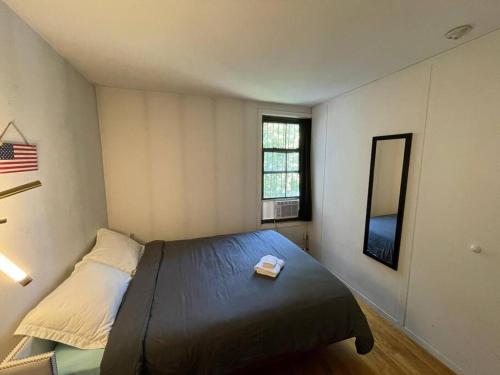 a small bedroom with a bed and a mirror at Comfy Room at great Townhouse in Williamsburg in Brooklyn