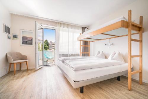 a bedroom with a bunk bed and a balcony at Wanderlust Guesthouse in Weggis