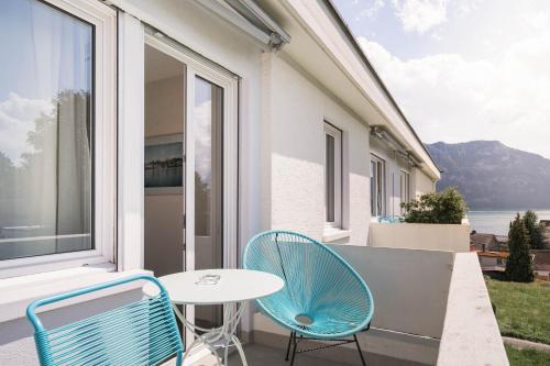 a patio with two chairs and a table and a window at Wanderlust Guesthouse in Weggis